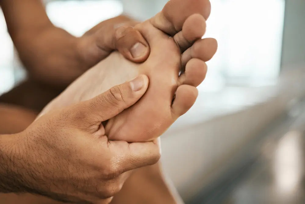 person holding their barefoot at the ball of the foot