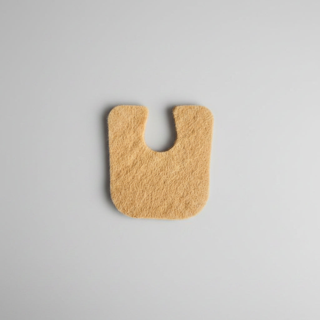 Adhesive felt callus protector pad a gray background