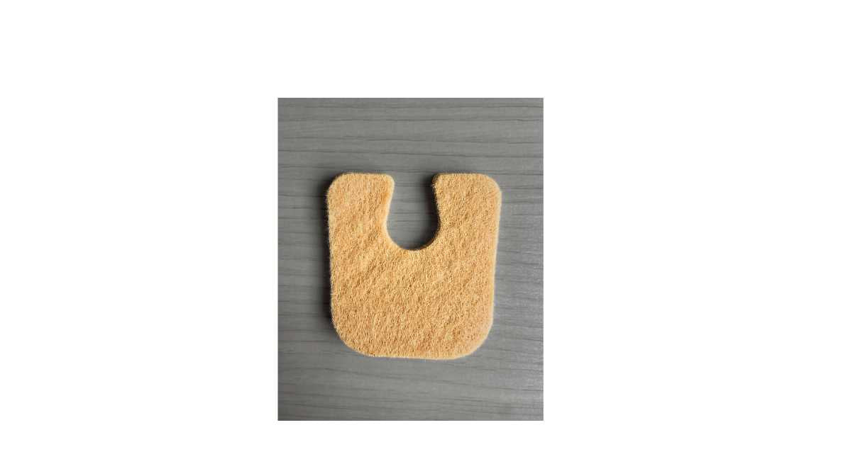 Adhesive felt callus protector pad a gray background